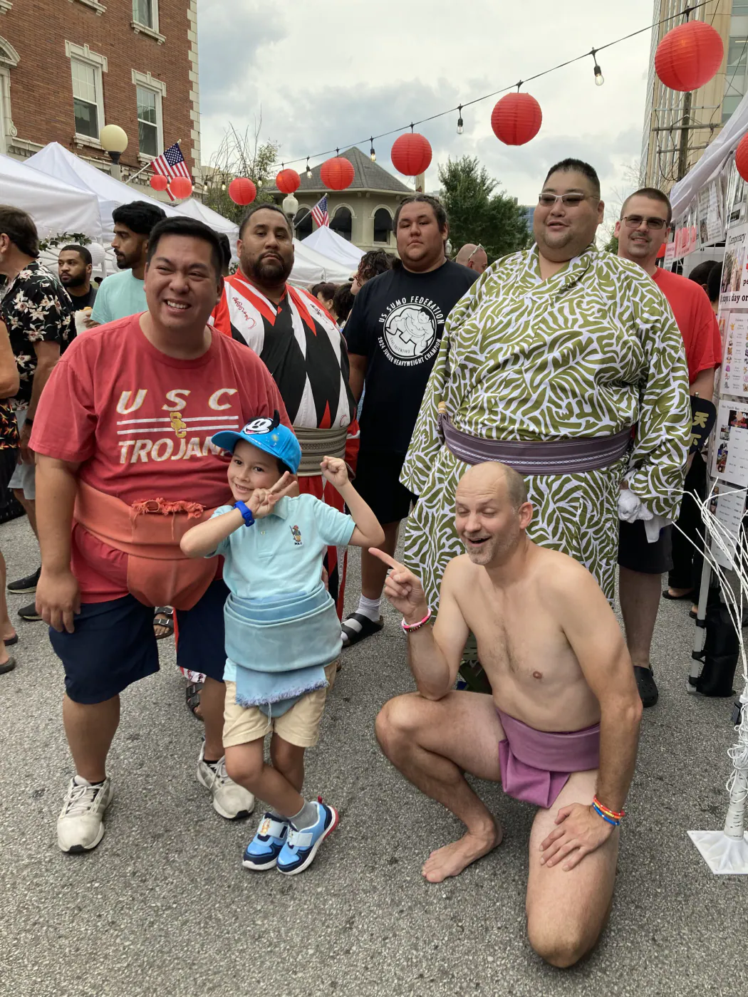 Club members posing with a child under festival lanterns